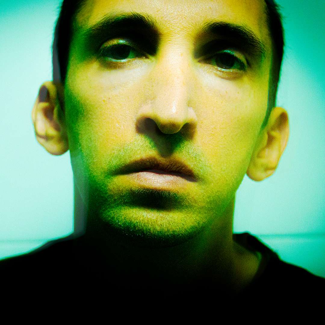 Portrait of Deniz Yildiz looking directly into the camera with a glum expression.